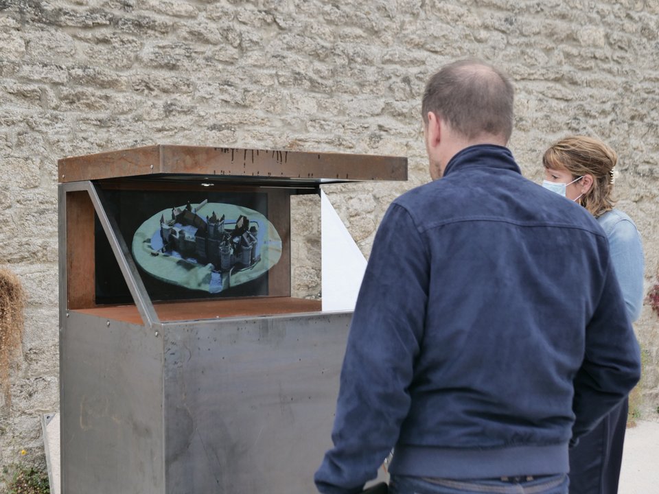 Un homme regarde l'hologramme du château d'Alençon