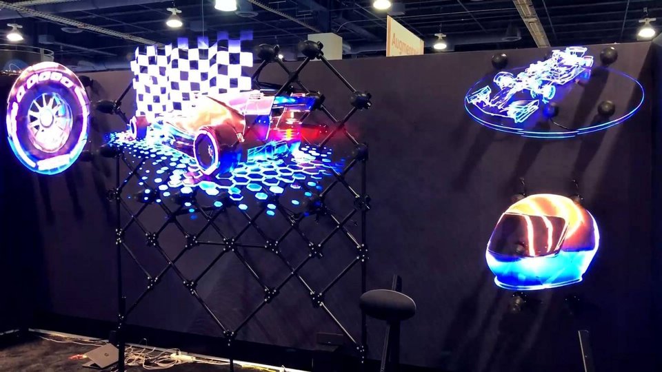 wall of holographic fans showing racing cars