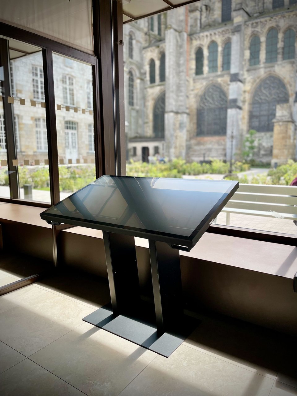Photo d'une table tactile installée dans la coursive du Musée du cloître de Notre-Dame-en-Vaux